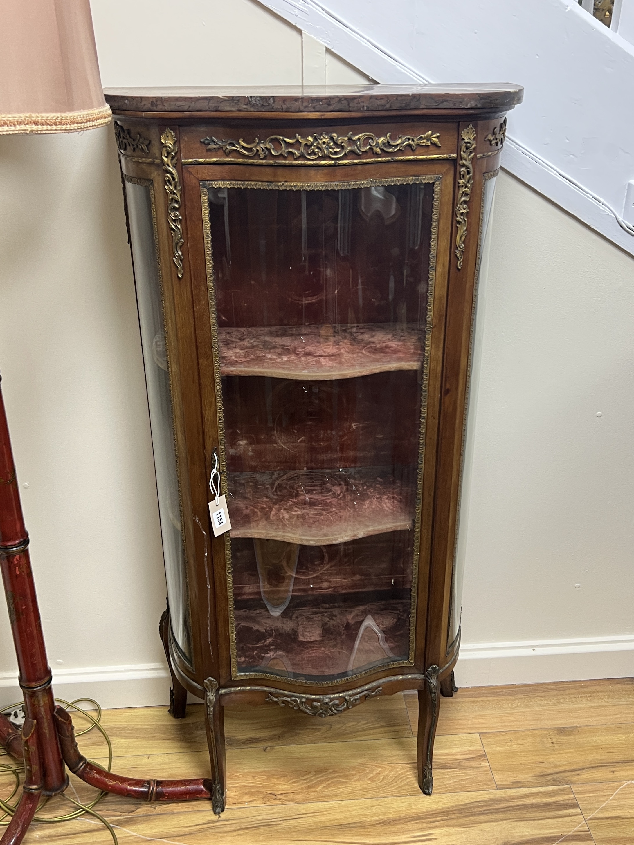 A Louis XVI style gilt metal mounted marble topped serpentine vitrine, width 70cm, depth 33cm, height 140cm